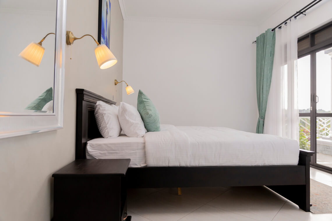 Well laid bed with white beddings and black frame